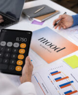 Equipo de marketing calculando el presupuesto de marketing de una empresa con gráficos de rendimiento y hoja de cálculo